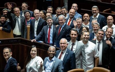 رئيس الوزراء بنيامين نتنياهو، مع وزير المالية بتسلئيل سموتريتش إلى جانبه، ووزراء آخرون في الائتلاف وأعضاء كنيست يحتفلون بإقرار ميزانية الدولة في الكنيست، 23 مايو 2023 (Yonatan Sindel / Flash90)