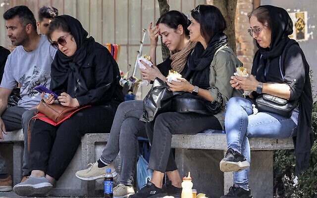 توضيحية: نساء يأكلن سندويشات أثناء جلوسهن خارج البازار الكبير في طهران، 5 سبتمبر، 2023. (Atta Kenare/AFP) توضيحية: نساء يأكلن سندويشات أثناء جلوسهن خارج البازار الكبير في طهران، 5 سبتمبر، 2023. (Atta Kenare/AFP)