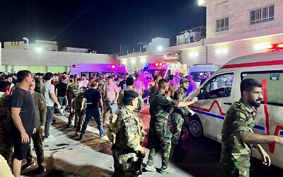 جنود ومسعفون يتجمعون حول سيارات الإسعاف التي تحمل جرحى بعد اندلاع حريق خلال حفل زفاف في قاعة مناسبات، خارج مستشفى الحمدانية العام في الحمدانية، العراق، 27 سبتمبر 2023. (Zaid AL-OBEIDI / AFP)