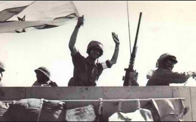 جندي من الجيش الإسرائيلي يلوح بالعلم الإسرائيلي  في طريقه إلى دمشق خلال حرب يوم الغفران، أكتوبر 1973. (State Archives)