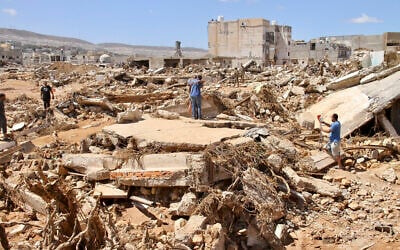 أشخاص يبحثون عن ناجين في درنة، ليبيا، 13 سبتمبر، 2023. (AP Photo/Yousef Murad)