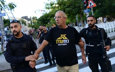 الشرطة تعتقل ناشطا يحتج على إقامة الجماعة اليهودية الحريدية "روش يهودي" حاجزا للفصل بين الجنسين مصنوع من الأعلام الإسرائيلية في تحد لأمر المحكمة العليا خلال صلاة عامة في ميدان ديزنغوف، تل أبيب، يوم الغفران. 24 سبتمبر 2023. (Tomer Neuberg/Flash 90)