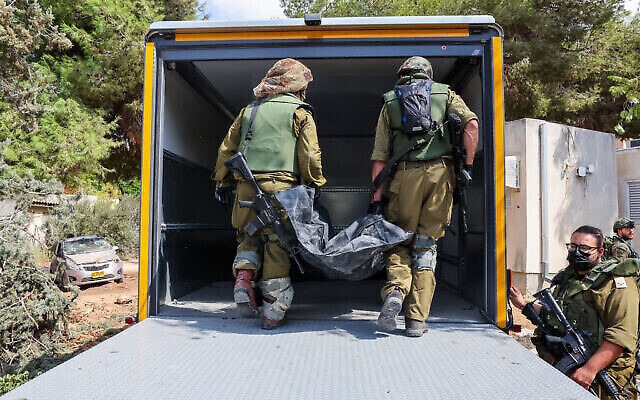 جنود إسرائيليون ينقلون جثة مواطن قُتل خلال هجوم نفذه مسلحون فلسطينيون في كفار عزة، جنوب إسرائيل على الحدود مع قطاع غزة، 10 أكتوبر، 2023. (JACK GUEZ / AFP) جنود إسرائيليون ينقلون جثة مواطن قُتل خلال هجوم نفذه مسلحون فلسطينيون في كفار عزة، جنوب إسرائيل على الحدود مع قطاع غزة، 10 أكتوبر، 2023. (JACK GUEZ / AFP)