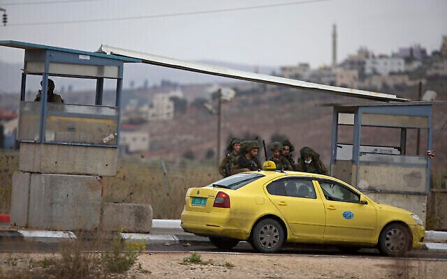 توضيحية: جنود إسرائيليون يتفقدون سيارة أجرة فلسطينية بعد أن فتح مسلح فلسطيني النار على موقع عسكري وردت القوات بإطلاق النار، عند حاجز حوارة جنوب مدينة نابلس بالضفة الغربية، 4 نوفمبر، 2020. (AP Photo/Majdi Mohammed)
