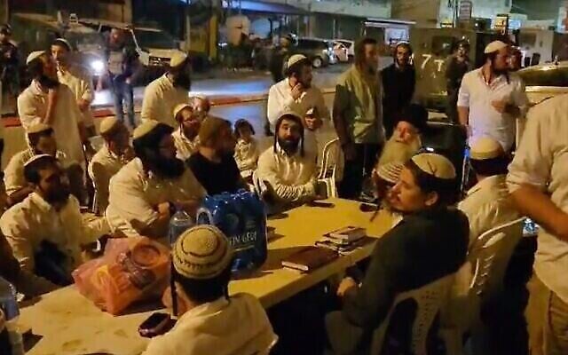 عضو الكنيست تسفي سوكوت من حزب  "الصهيونية المتدينة" اليميني المتطرف ويهود إسرائيليون آخرون يصلون في حوارة، بعد أن نصب سوكوت عريشة في البلدة الفلسطينية احتجاجا على هجوم إطلاق نار وقع هناك، 5 أكتوبر، 2023.  (X. Used in accordance with Clause 27a of the Copyright Law)