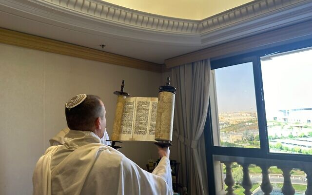 أحد أعضاء وفد وزير الاتصالات شلومو كرعي يحمل لفافة توراة خلال صلاة صباحية في الرياض، المملكة العربية السعودية، 3 أكتوبر، 2023. (Spokesman’s Office, Communications Ministry)