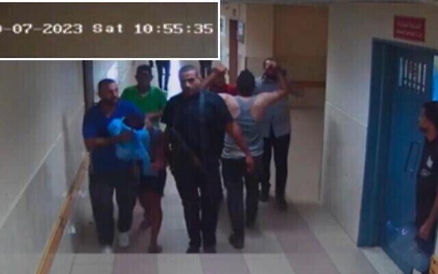 مقاتلو حماس يحضرون رهينة إلى مستشفى الشفاء، كما يظهر في لقطات كاميرات المراقبة في 7 أكتوبر، 2023. (IDF) مقاتلو حماس يحضرون رهينة إلى مستشفى الشفاء، كما يظهر في لقطات كاميرات المراقبة في 7 أكتوبر، 2023. (IDF)
