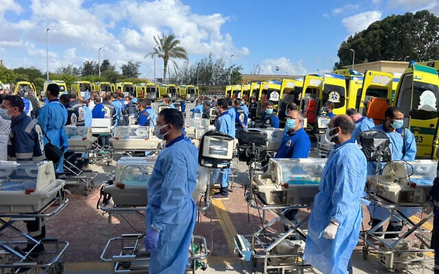 مسعفون مصريون ينتظرون مع حاضنات لاستقبال أطفال فلسطينيين خدج تم إجلاؤهم من غزة، على الجانب المصري من معبر رفح الحدودي مع قطاع غزة، 20 نوفمبر 2023. (AFP) مسعفون مصريون ينتظرون مع حاضنات لاستقبال أطفال فلسطينيين خدج تم إجلاؤهم من غزة، على الجانب المصري من معبر رفح الحدودي مع قطاع غزة، 20 نوفمبر 2023. (AFP)
