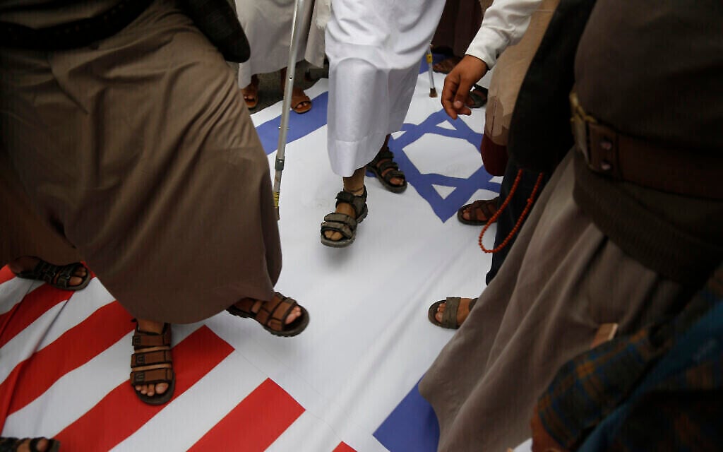 أنصار الحوثيين يدوسون على العلمين الأمريكي والإسرائيلي، 26 مارس 2023، في صنعاء، اليمن. (AP Photo/Hani Mohammed)