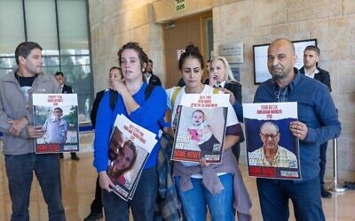 عائلات الإسرائيليين المحتجزين كرهائن من قبل مسلحي حماس في غزة خارج اجتماع لجنة الدفاع والشؤون الخارجية في الكنيست بالقدس في 11 ديسمبر، 2023. يفعات زيلر – ابنة عم الرهينة شيري بيباس، التي يتم احتجاز طفليها وزوجها أيضا  - في الجهة اليسرى من الأمام. أوفري بيباس في الوسط. (Yonatan Sindel/Flash90)