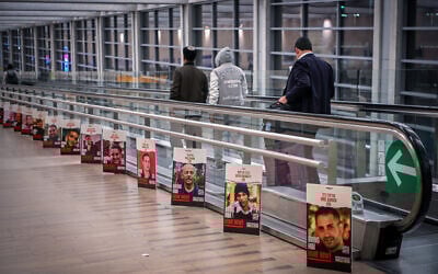 صور لإسرائيليين محتجزين لدى مسلحي حماس في قطاع غزة، في مطار بن غوريون الدولي بالقرب من تل أبيب، 26 ديسمبر، 2023. (Arie Leib Abrams/Flash90)