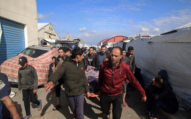 فلسطينيون يحملون جثة شخص قُتل في قصف على مركز للتدريب المهني تابع للأونروا، والذي يستخدمه النازحون كمأوى في خان يونس، جنوب قطاع غزة، الأربعاء، 24 يناير، 2024. (AP Photo/Ramez Habboub) فلسطينيون يحملون جثة شخص قُتل في قصف على مركز للتدريب المهني تابع للأونروا، والذي يستخدمه النازحون كمأوى في خان يونس، جنوب قطاع غزة، الأربعاء، 24 يناير، 2024. (AP Photo/Ramez Habboub)