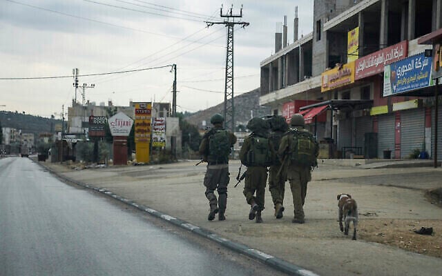 توضيحية: جنود إسرائيليون في دورية في بلدة حوارة الفلسطينية المضطربة، 12 نوفمبر، 2023. (AP Photo/Mahmoud Illean) توضيحية: جنود إسرائيليون في دورية في بلدة حوارة الفلسطينية المضطربة، 12 نوفمبر، 2023. (AP Photo/Mahmoud Illean)
