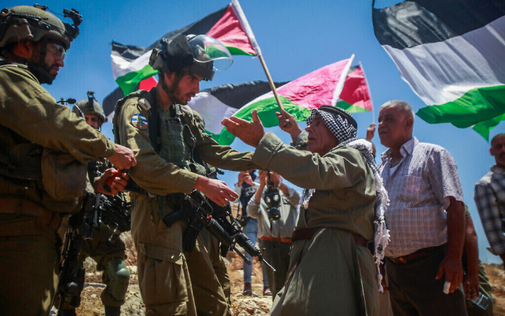 ملف: جنود إسرائيليون يقفون للحراسة خلال مظاهرة لفلسطينيين ونشطاء من اليسار في قرية بيت دجن بالضفة الغربية، 30 يونيو، 2023. (Nasser Ishtayeh/Flash90) ملف: جنود إسرائيليون يقفون للحراسة خلال مظاهرة لفلسطينيين ونشطاء من اليسار في قرية بيت دجن بالضفة الغربية، 30 يونيو، 2023. (Nasser Ishtayeh/Flash90)