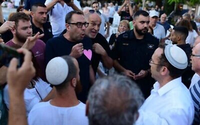 اشتباكات بين ناشطين علمانيين ومتدينين بعد أن قامت منظمة "روش يهودي" الدينية بوضع حاجز يفصل بين الجنسين مصنوع من الأعلام الإسرائيلية في تحد لقرار البلدية في صلاة عامة في ميدان ديزنغوف، تل أبيب، يوم الغفران، 24 سبتمبر، 2023.  (Tomer Neuberg/Flash 90)