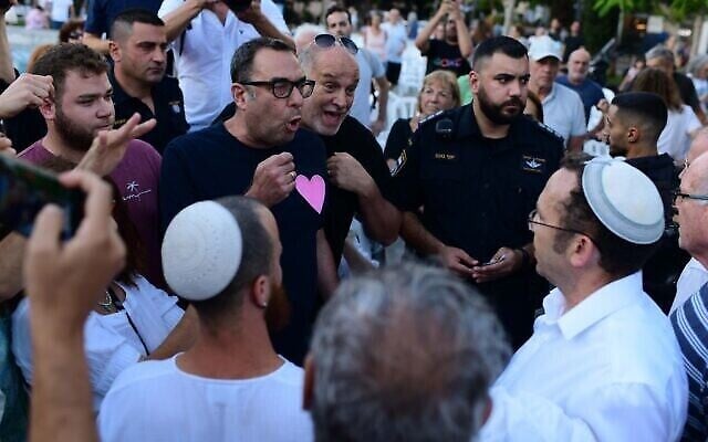 اشتباكات بين ناشطين علمانيين ومتدينين بعد أن قامت منظمة "روش يهودي" الدينية بوضع حاجز يفصل بين الجنسين مصنوع من الأعلام الإسرائيلية في تحد لقرار البلدية في صلاة عامة في ميدان ديزنغوف، تل أبيب، يوم الغفران، 24 سبتمبر، 2023.  (Tomer Neuberg/Flash 90)