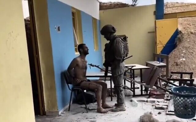 جندي إسرائيلي يقف فوق مشتبه به فلسطيني في غزة في لقطات غير مؤرخة تم تحميلها على وسائل التواصل الاجتماعي، 2 فبراير، 2024. (Screen Capture/X) جندي إسرائيلي يقف فوق مشتبه به فلسطيني في غزة في لقطات غير مؤرخة تم تحميلها على وسائل التواصل الاجتماعي، 2 فبراير، 2024. (Screen Capture/X)