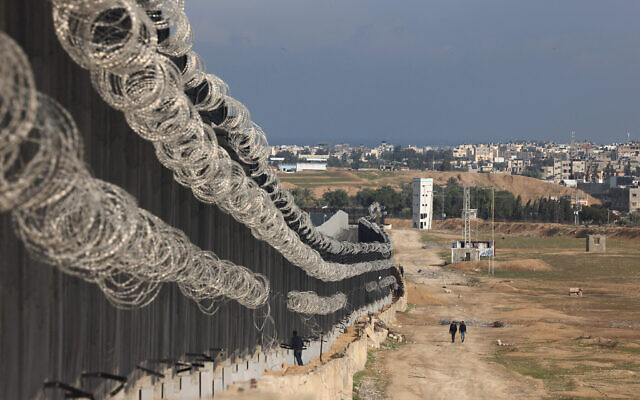 نازحون فلسطينيون يسيرون بجوار السياج الحدودي بين غزة ومصر في رفح، 16 فبراير 2024. (Mohammed Abed/AFP) نازحون فلسطينيون يسيرون بجوار السياج الحدودي بين غزة ومصر في رفح، 16 فبراير 2024. (Mohammed Abed/AFP)