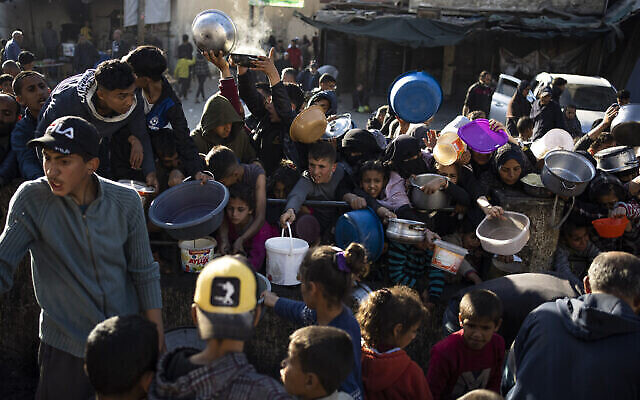 فلسطينيون يصطفون لتناول وجبة في رفح، قطاع غزة، الثلاثاء، 12 مارس، 2024. (AP/Fatima Shbair)