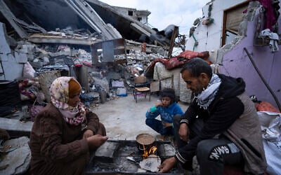 فلسطينيون يتناولون الإفطار خلال شهر رمضان المبارك خارج منزلهم المدمر في رفح، قطاع غزة، 18 مارس، 2024. (AP Photo/Fatima Shbair)