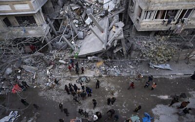 فلسطينيون يتفقدون الأضرار التي لحقت بالمباني السكنية بعد غارة جوية إسرائيلية في رفح، جنوب قطاع غزة، 24 مارس، 2024. (AP Photo/Fatima Shbair)