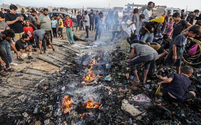 فلسطينيون يتفقدون الأضرار بعد غارة جوية إسرائيلية على ما قال الجيش الإسرائيلي إنه مجمع تابع لحماس، مجاور لمخيم للنازحين في رفح، قطاع غزة، 27 مايو، 2024. (Abed Rahim Khatib/Flash90) فلسطينيون يتفقدون الأضرار بعد غارة جوية إسرائيلية على ما قال الجيش الإسرائيلي إنه مجمع تابع لحماس، مجاور لمخيم للنازحين في رفح، قطاع غزة، 27 مايو، 2024. (Abed Rahim Khatib/Flash90)