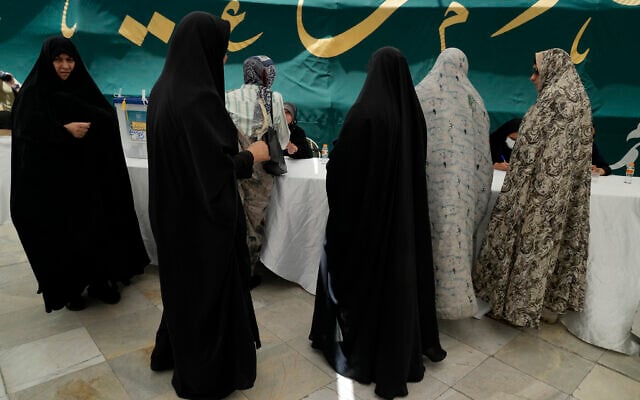نساء يحصلن على أوراق الاقتراع خلال الانتخابات الرئاسية الإيرانية في مركز اقتراع في شمال طهران، 28 يونيو، 2024. (AP/Vahid Salemi) نساء يحصلن على أوراق الاقتراع خلال الانتخابات الرئاسية الإيرانية في مركز اقتراع في شمال طهران، 28 يونيو، 2024. (AP/Vahid Salemi)