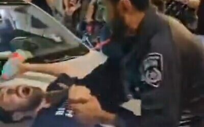عناصر شرطة يدفعون متظاهرًا مناهضًا للحكومة خلال مظاهرة في ساحة باريس بالقدس في 29 يونيو، 2024. (Screenshot: X; used in accordance with Clause 27a of the Copyright Law)