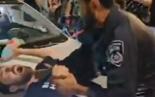 عناصر شرطة يدفعون متظاهرًا مناهضًا للحكومة خلال مظاهرة في ساحة باريس بالقدس في 29 يونيو، 2024. (Screenshot: X; used in accordance with Clause 27a of the Copyright Law)