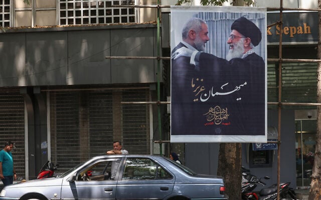 أشخاص يمرون أمام لافتة تحمل صورة للمرشد الأعلى الإيراني آية الله علي خامنئي (إلى اليمين) ورئيس المكتب السياسي لحركة حماس إسماعيل هنية، الذي اغتيل في طهران، في العاصمة الإيرانية طهران، 10 أغسطس، 2024. (ATTA KENARE / AFP) أشخاص يمرون أمام لافتة تحمل صورة للمرشد الأعلى الإيراني آية الله علي خامنئي (إلى اليمين) ورئيس المكتب السياسي لحركة حماس إسماعيل هنية، الذي اغتيل في طهران، في العاصمة الإيرانية طهران، 10 أغسطس، 2024. (ATTA KENARE / AFP)