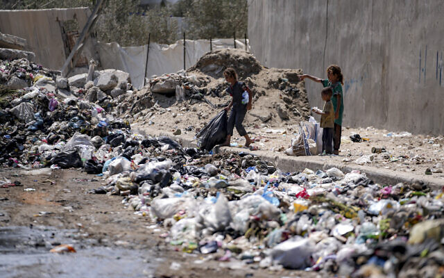 أطفال فلسطينيون نازحون بين أكوام القمامة في أحد شوارع دير البلح، وسط قطاع غزة، 27 أغسطس 2024. (AP Photo/Abdel Kareem Hana) أطفال فلسطينيون نازحون بين أكوام القمامة في أحد شوارع دير البلح، وسط قطاع غزة، 27 أغسطس 2024. (AP Photo/Abdel Kareem Hana)
