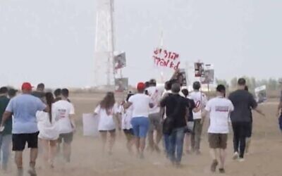 لقطة شاشة من مقطع فيديو يظهر أقارب الرهائن الإسرائيليين المحتجزين في غزة يتظاهرون في كيبوتس نيريم على طول السياج الحدودي بين إسرائيل وغزة، 29 أغسطس، 2024.  (Nir Kafri/AFPTV/AFP)