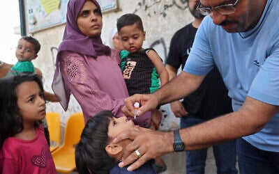 عامل صحي يعطي لقاح شلل الأطفال لطفل فلسطيني في الزوايدة في وسط قطاع غزة في 1 سبتمبر 2024، وسط الصراع المستمر بين إسرائيل وحركة حماس. ( Eyad BABA / AFP)