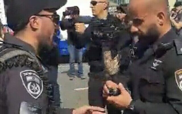 ضابط الشرطة الإسرائيلي مئير سويسا (يمين) يجهز قنبلة صوتية قبل لحظات من إلقائها على حشد من المتظاهرين خلال احتجاج مناهض للحكومة في تل أبيب، 1 مارس 2023. (Video screenshot; used in accordance with Clause 27a of the Copyright Law) ضابط الشرطة الإسرائيلي مئير سويسا (يمين) يجهز قنبلة صوتية قبل لحظات من إلقائها على حشد من المتظاهرين خلال احتجاج مناهض للحكومة في تل أبيب، 1 مارس 2023. (Video screenshot; used in accordance with Clause 27a of the Copyright Law)
