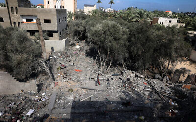 طفل يمشي وسط أنقاض منزل تعرض للقصف في غارة إسرائيلية في دير البلح وسط قطاع غزة، 4 أكتوبر، 2024. (Eyad Baba/AFP)