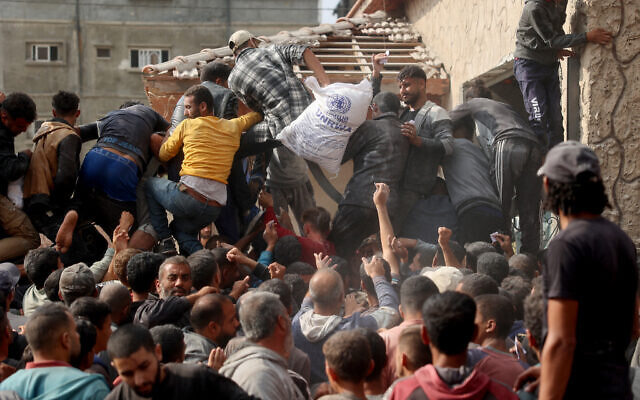 نازحون فلسطينيون يتدافعون للحصول على أكياس الدقيق في مركز توزيع مساعدات وكالة الأمم المتحدة لإغاثة وتشغيل اللاجئين الفلسطينيين (الأونروا) في دير البلح وسط قطاع غزة في 3 نوفمبر 2024. (Eyad Baba/AFP) نازحون فلسطينيون يتدافعون للحصول على أكياس الدقيق في مركز توزيع مساعدات وكالة الأمم المتحدة لإغاثة وتشغيل اللاجئين الفلسطينيين (الأونروا) في دير البلح وسط قطاع غزة في 3 نوفمبر 2024. (Eyad Baba/AFP)
