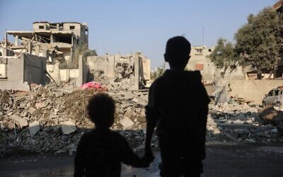 طفلان ينظران إلى الدمار في أعقاب غارة إسرائيلية على مخيم النصيرات في وسط قطاع غزة، 7 نوفمبر، 2024. (Eyad BABA / AFP)