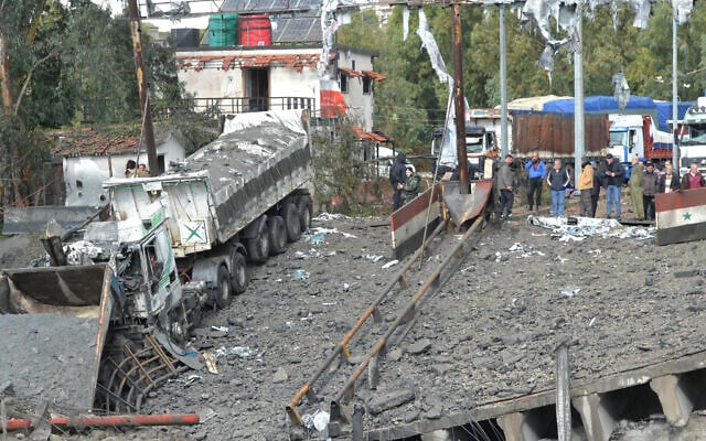 توضيحية: صورة مأخوذة من لبنان تظهر مسؤولين سوريين يتفقدون الأضرار على الجانب السوري من معبر الدبوسية الحدودي بعد غارة جوية إسرائيلية في 27 نوفمبر، 2024. (Fathi AL-MASRI / AFP) توضيحية: صورة مأخوذة من لبنان تظهر مسؤولين سوريين يتفقدون الأضرار على الجانب السوري من معبر الدبوسية الحدودي بعد غارة جوية إسرائيلية في 27 نوفمبر، 2024. (Fathi AL-MASRI / AFP)