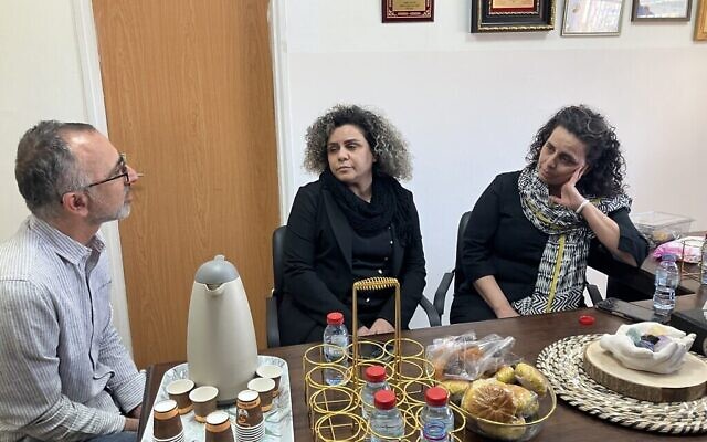 عضو منظمة “تاغ مئير”، يوسي سايدوف (على اليسار)، يعتذر لهنا يونس (في الوسط) ونجلاء عواد (على اليمين) بسبب التعليقات العنصرية على وسائل التواصل الاجتماعي حول شقيقتهما صفاء عواد، التي قُتلت جراء سقوط صاروخ أطلقه حزب الله في 18 نوفمبر، 2024. (Diana Bletter/Times of Israel)