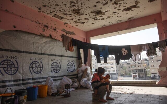 توضيحية: طفلة فلسطينية نازحة تحمل طفلاً رضيعًا داخل مدرسة تابعة للأمم المتحدة في حي ناصر بمدينة غزة، شمال قطاع غزة، 25 أكتوبر 2024. (Omar AL-QATTAA / AFP) توضيحية: طفلة فلسطينية نازحة تحمل طفلاً رضيعًا داخل مدرسة تابعة للأمم المتحدة في حي ناصر بمدينة غزة، شمال قطاع غزة، 25 أكتوبر 2024. (Omar AL-QATTAA / AFP)