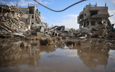 فلسطينيون يتفقدون الدمار مع عودة السكان النازحين إلى النصيرات في وسط قطاع غزة بعد توقف قصف المخيم في 29 نوفمبر، 2024. (Eyad Baba/AFP)