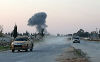مقاتلون مناهضون للنظام يقودون سياراتهم على طول الطريق السريع حلب-دمشق M5 في منطقة خان العسل الشمالية الغربية التي تم الاستيلاء عليها حديثًا، مع تصاعد الدخان في الأفق، 29 نوفمبر، 2024 (Omar HAJ KADOUR / AFP)
