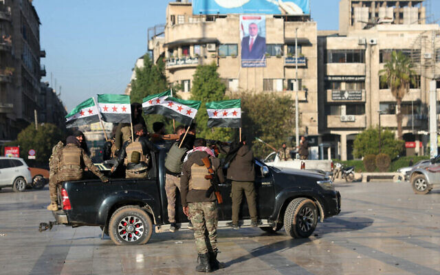 مقاتلون مناهضون للحكومة يلوحون بأعلام المعارضة في مدينة حلب بشمال سوريا في 30 نوفمبر 2024، وسط هجوم خاطف ضد قوات الحكومة المدعومة من إيران وروسيا. (Omar Haj Kadour/AFP) مقاتلون مناهضون للحكومة يلوحون بأعلام المعارضة في مدينة حلب بشمال سوريا في 30 نوفمبر 2024، وسط هجوم خاطف ضد قوات الحكومة المدعومة من إيران وروسيا. (Omar Haj Kadour/AFP)