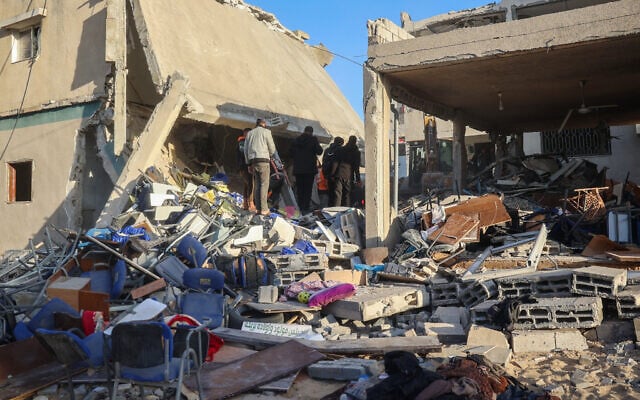 رجال إنقاذ ومواطنون يبحثون بين أنقاض مبنى عن ضحايا في أعقاب غارة إسرائيلية على مبنى البلدية في دير البلح وسط قطاع غزة في 14 ديسمبر، 2024. ( Eyad Baba/AFP) رجال إنقاذ ومواطنون يبحثون بين أنقاض مبنى عن ضحايا في أعقاب غارة إسرائيلية على مبنى البلدية في دير البلح وسط قطاع غزة في 14 ديسمبر، 2024. ( Eyad Baba/AFP)