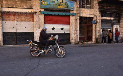 رجل سوري يركب دراجته النارية في قرية معلولا شمال العاصمة السورية دمشق في 15 ديسمبر 2024.  (Fadel ITANI / AFP)