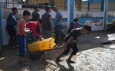 فلسطينيون يجمعون مياه الشرب في محطة تحلية مياه تعمل الآن على مدار الساعة في دير البلح، غزة، 14 نوفمبر 2024. (AP/Abdel Kareem Hana)