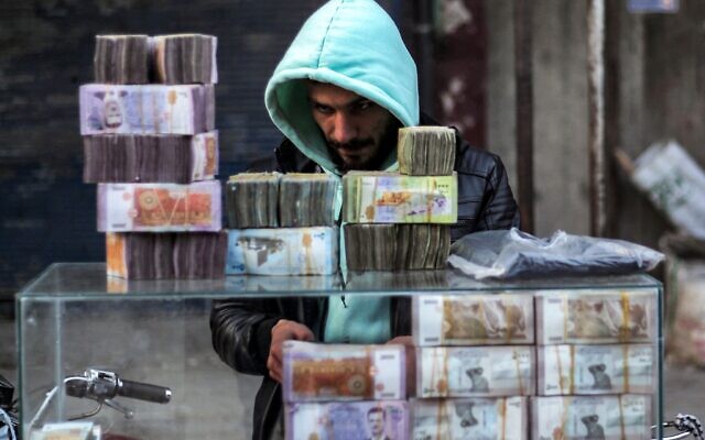 أكوام من أوراق الليرة السورية مكدسة في كشك صراف في سوق في مدينة منبج، محافظة حلب شمال سوريا، في 4 يناير 2025. (Aaref WATAD / AFP) أكوام من أوراق الليرة السورية مكدسة في كشك صراف في سوق في مدينة منبج، محافظة حلب شمال سوريا، في 4 يناير 2025. (Aaref WATAD / AFP)
