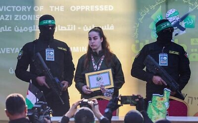 الجندية المحتجزة أغام بيرغر تظهر على خشبة منصة في جباليا شمال غزة، محاطة بمسلحين من حماس، قبل تسليمها إلى الصليب الأحمر، في 30 يناير 2025 (Omar AL-QATTAA / AFP)