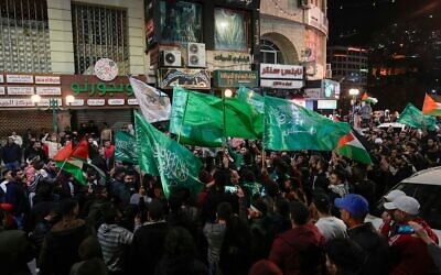 فلسطينيون يلوحون بأعلام حماس أثناء احتفالهم بالإفراج عن أسرى فلسطينيين في نابلس بالضفة الغربية، 24 نوفمبر 2023. (AP Photo/Majdi Mohammed)