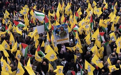 فلسطينيون يحملون رايات حركة فتح الصفراء أثناء تظاهرهم دعماً لقوات الأمن الفلسطينية في مخيم جنين للاجئين في شمال الضفة الغربية، 29 ديسمبر، 2024. (AP Photo/Majdi Mohammed)
